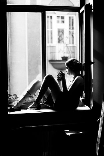 Sitzende Frau auf der Fensterbank